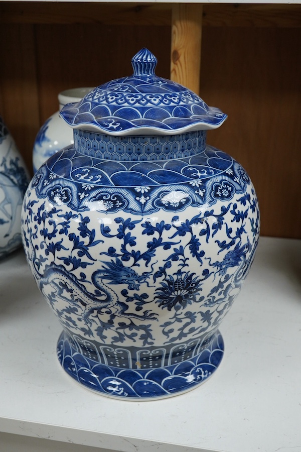 Three blue and white Chinese porcelain vases, a similar jar and cover, plus three stacking jars and covers on stand, a large dragon designed charger on stand and a similar decorated vase, charger 39cm diameter (7). Condi